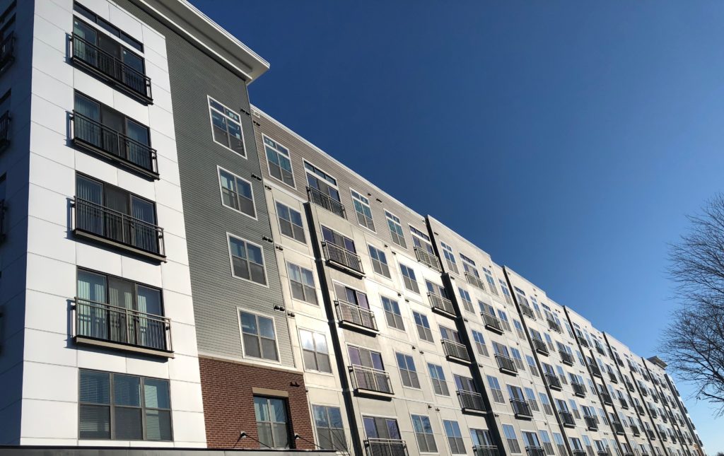 Black aluminum Juliet balconies on modern multi-story residential building facade