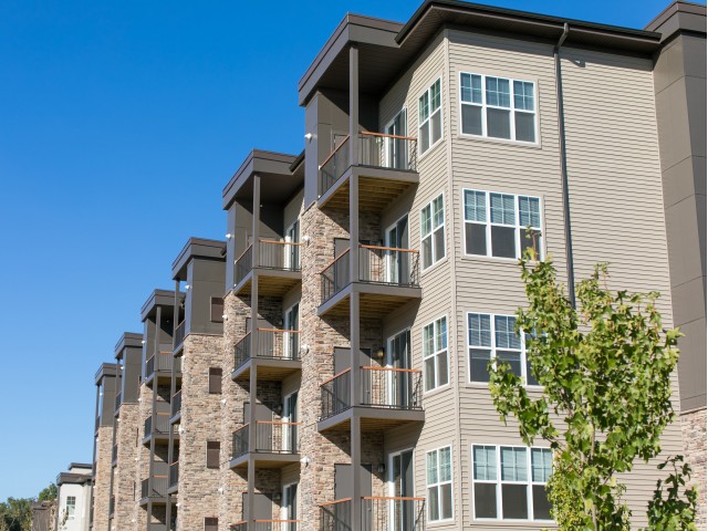 Black aluminum railing with wood top on balconies of residential apartment building