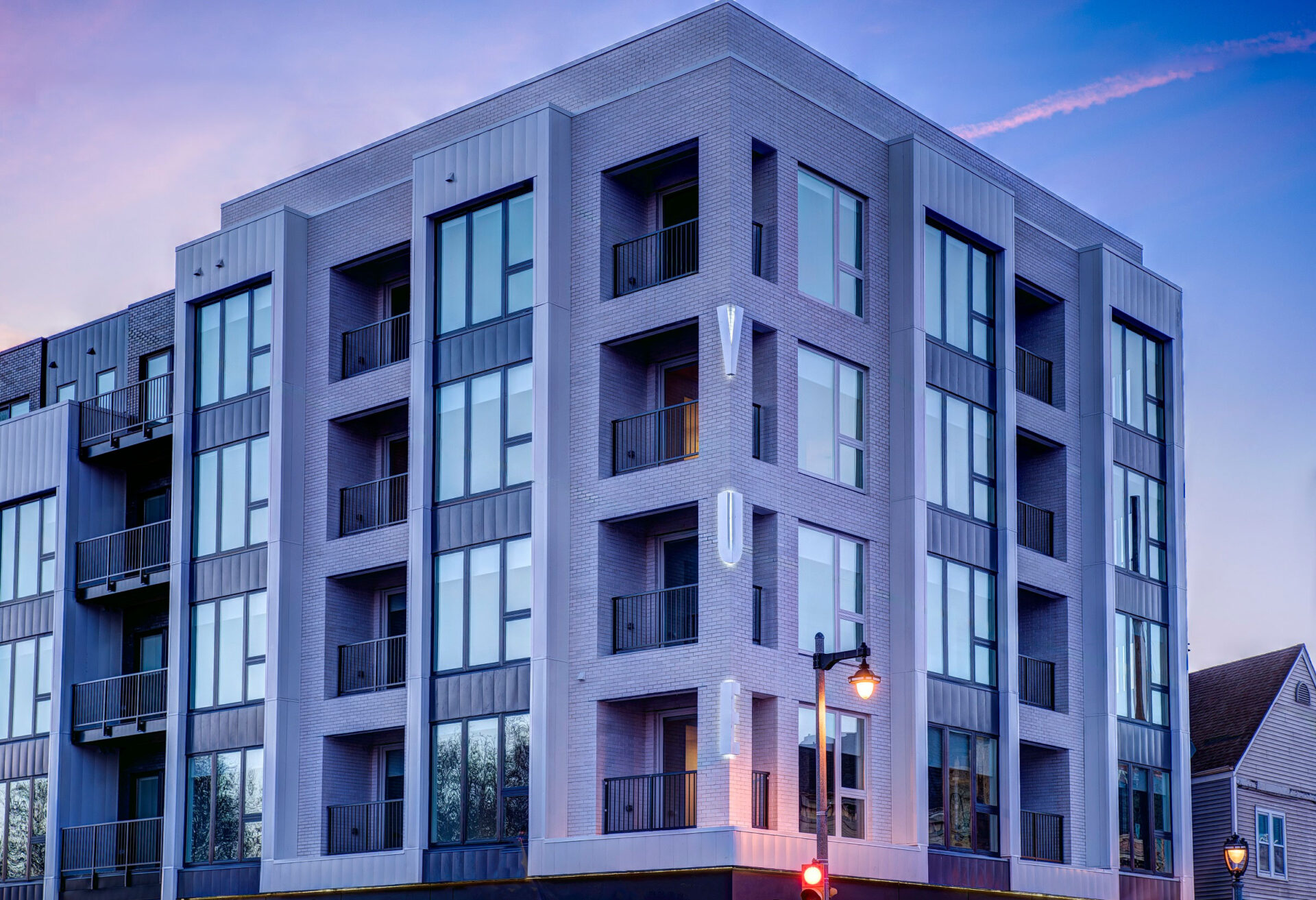 Mixed-Use Building at Dusk Modern mixed-use building with balconies and large windows at dusk