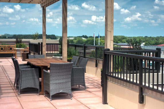 Black Aluminum Railing on Rooftop Patio Black aluminum railing on rooftop patio with outdoor dining furniture