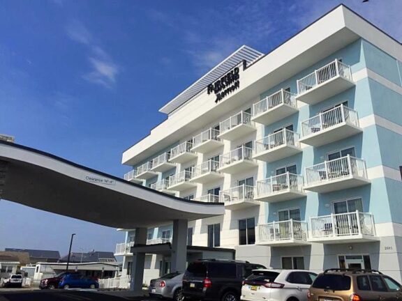White aluminum railing on balconies of light blue and white multi-story building