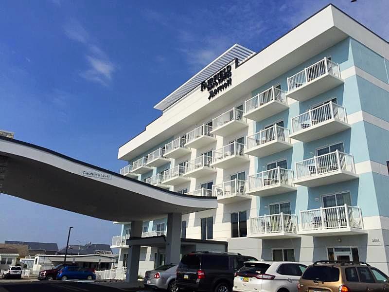 White aluminum railing on balconies of light blue and white multi-story building