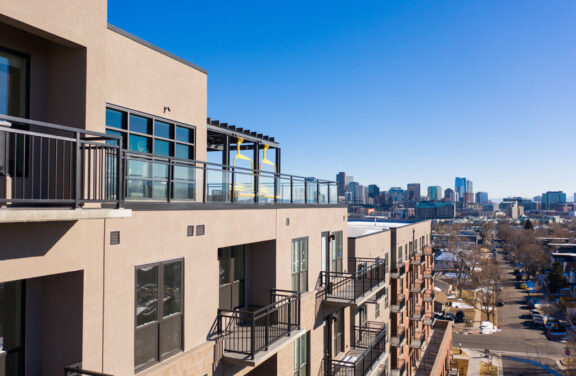 Black metal and glass railings on balconies and rooftop deck of modern apartment with city skyline