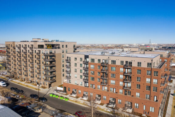 Aerial view of modern apartment buildings featuring multiple black metal railings on balconies