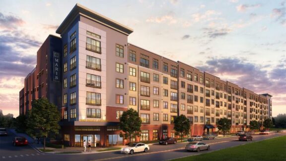Modern multi-story apartment building with black aluminum Juliet balconies at sunset