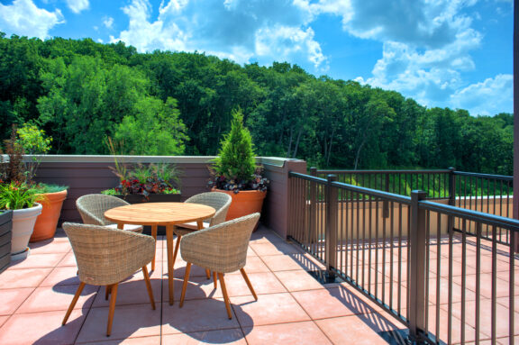 Black aluminum railing around rooftop patio of brick apartment building